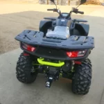 A green and black atv with a large tire.
