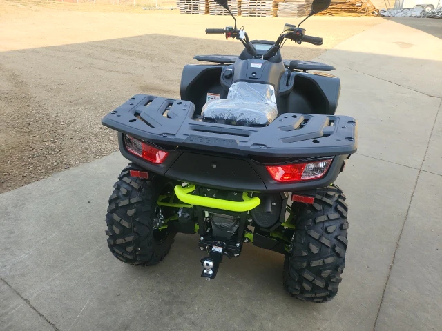 A green and black atv with a large tire.